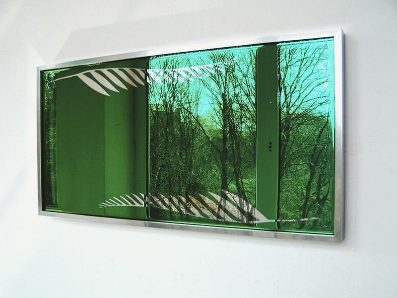 Зеленое зеркало с узором на стене